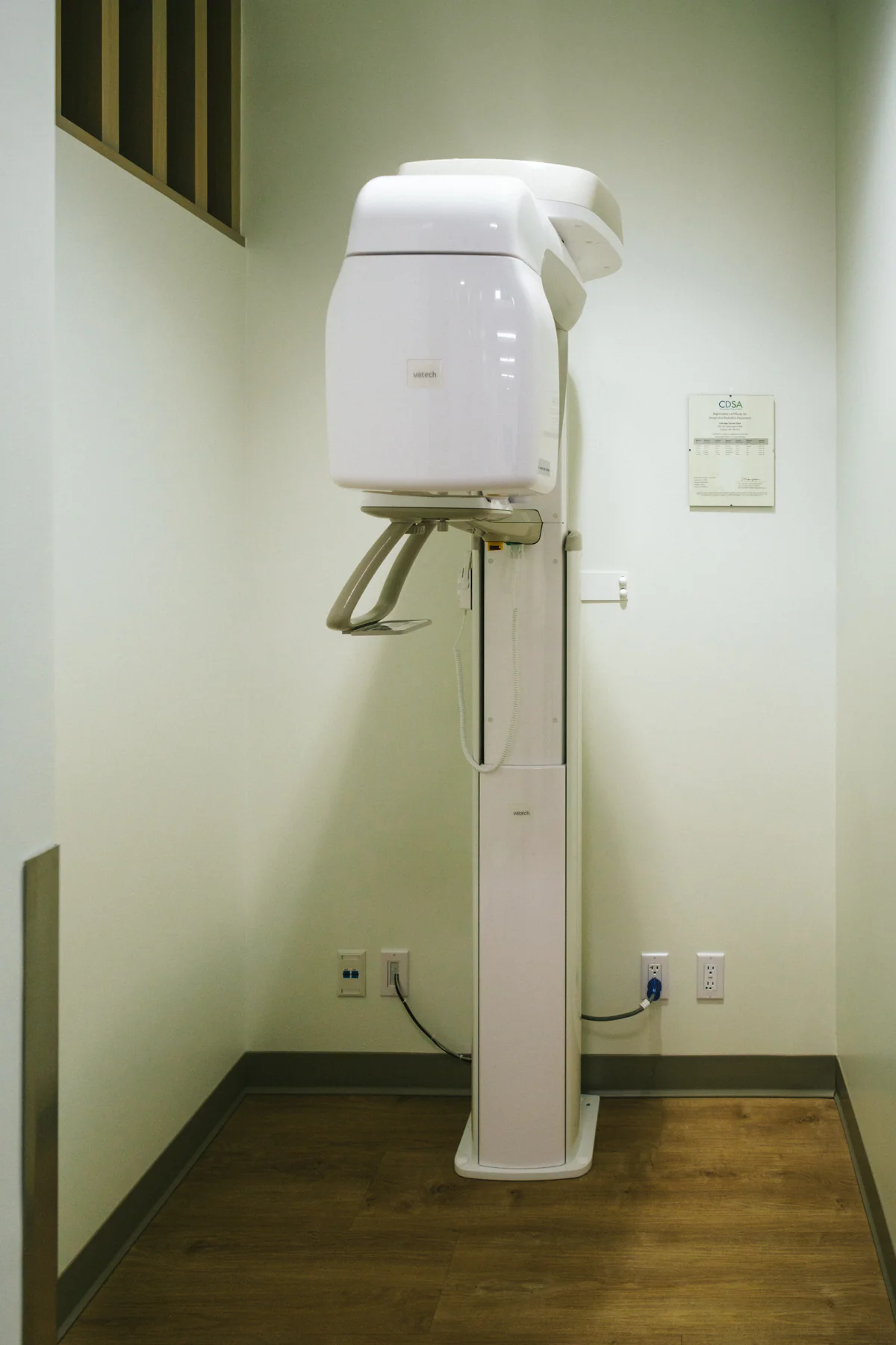 White dental imaging equipment in a clean clinic space